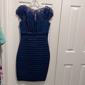 This is size 4 navy cocktail dress with lace on top that zips in the back.